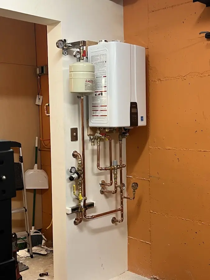 Plumbing technician inspecting water heater connections in Karns